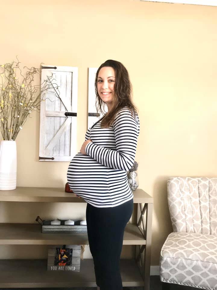 Photo of Jessica who is pregnant, smiling and ready for delivery day.